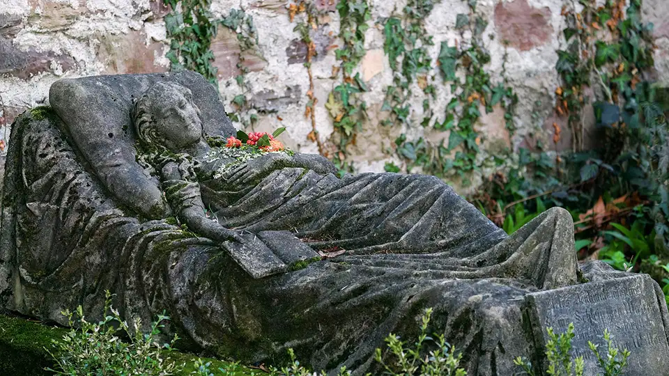 Elegant stone woman on stone bed with book