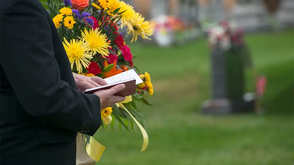 Man holding book at funeral service