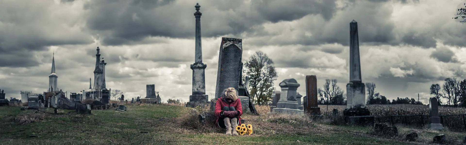 Person sitting in a graveyard