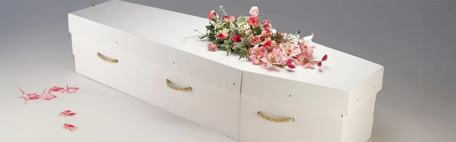 White cardboard coffin and flowers